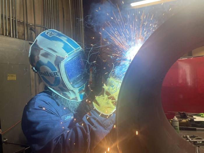 AWS certified welder joining a rolled steel section